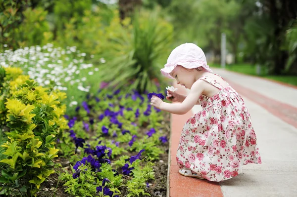 Adorable toddler girl holding two flowers — Stock Photo, Image
