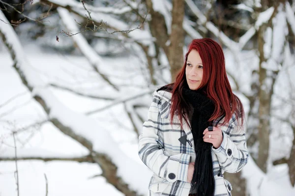 Jonge vrouw in besneeuwde bos — Stockfoto