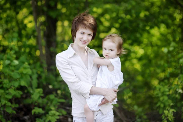 Jonge moeder houden haar schattig meisje — Stockfoto