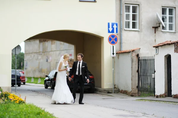 Bride and groom walking in a town — Stock Photo, Image