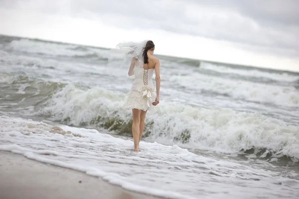 Невеста бежит вдоль морского побережья — стоковое фото