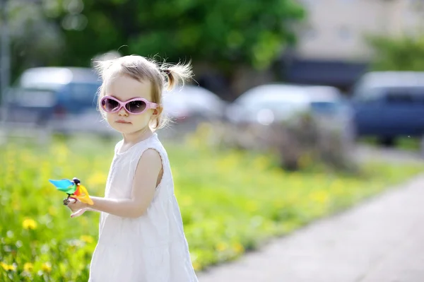 Menina engraçada com um brinquedo colorido — Fotografia de Stock