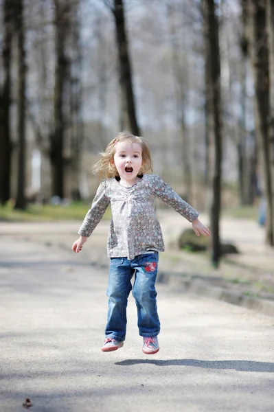 Очаровательная малышка, прыгающая на улицу — стоковое фото