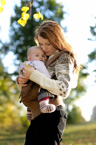 Jeune mère avec son bébé dans un porte-bébé — Photo