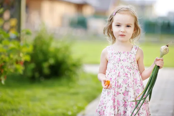 Klein meisje helpen in een tuin — Stockfoto