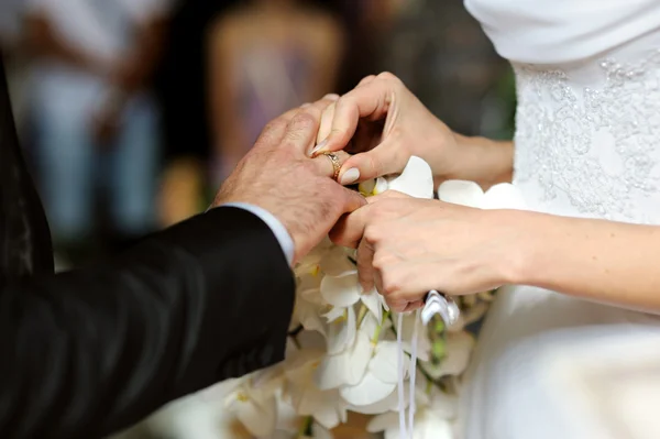 Novia poniendo el anillo en el dedo del novio — Foto de Stock