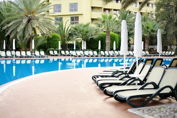 Ombrelloni bianchi in piscina al resort tropicale — Foto Stock