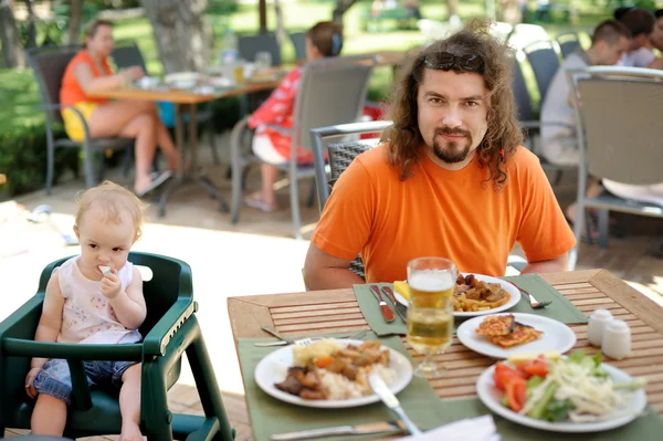 El joven padre y su hija pequeña comiendo. —  Fotos de Stock