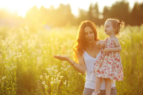 Ung mamma håller hennes bedårande flicka — Stockfoto