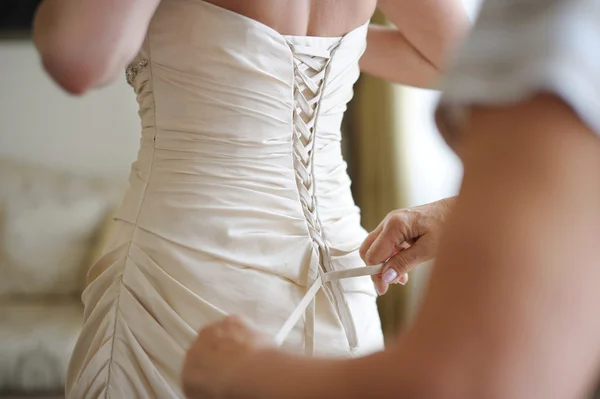Ayudar a una novia a ponerse su vestido de novia —  Fotos de Stock