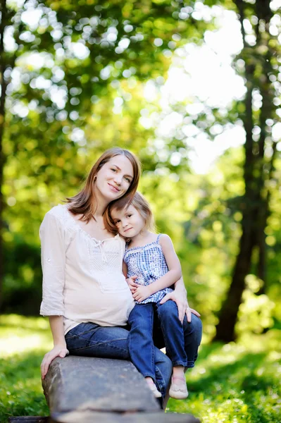 Mãe grávida com sua filha pequena — Fotografia de Stock