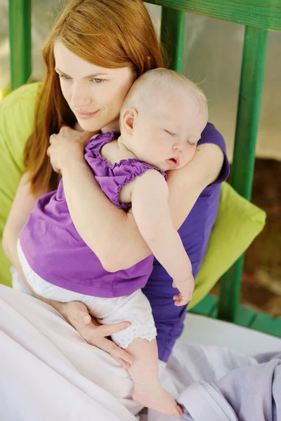 Bébé de huit mois dormant entre les mains des mères — Photo