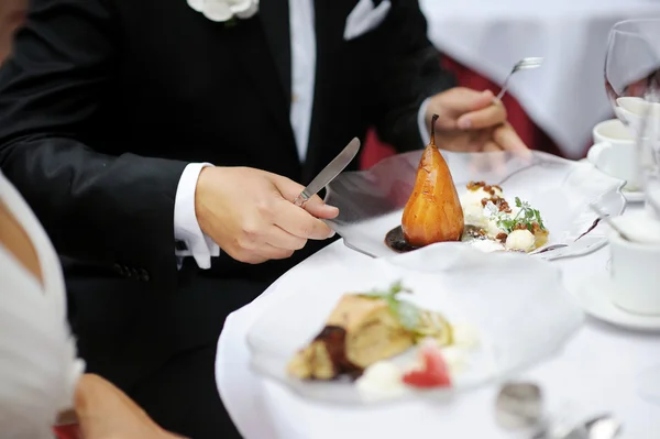 Comer pêra escalfada em um restaurante — Fotografia de Stock