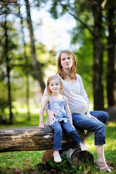 Liten flicka och hennes gravid mamma — Stockfoto