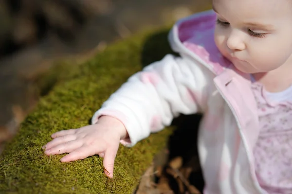 Liten flicka sitter i en skog med våren — Stockfoto