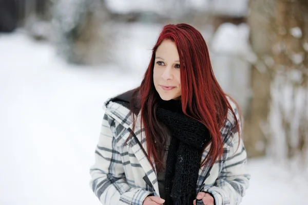 Jonge vrouw in besneeuwde bos — Stockfoto