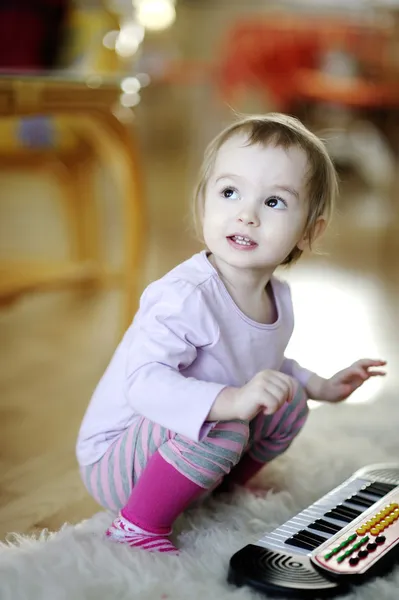 Malá dívka hrací hračky piano — Stock fotografie