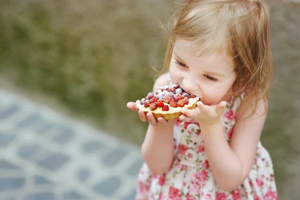 Lilla flickan äta en jordgubbe tårta — Stockfoto