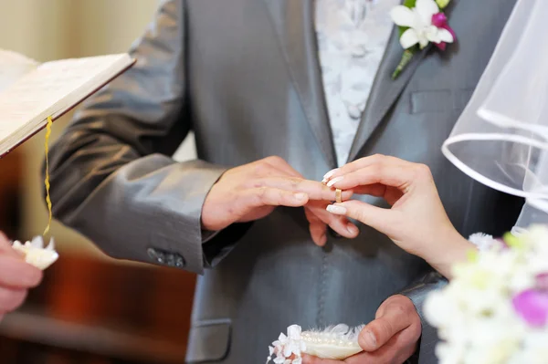 Braut steckt Bräutigam einen Ring an — Stockfoto