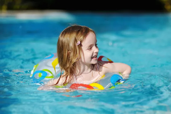 Całkiem mała dziewczynka pływanie w basenie — Zdjęcie stockowe