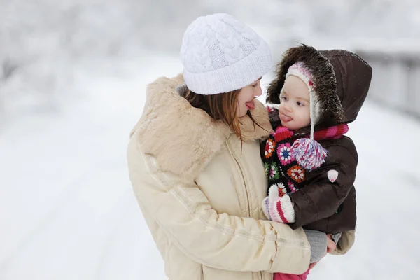 Babymeisje en haar moeder tonen hun tongen — Stockfoto