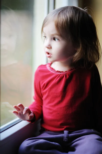 Entzückendes kleines Mädchen am Fenster — Stockfoto