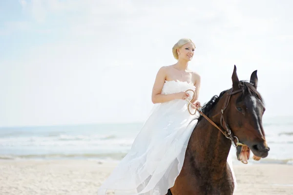 Novia en un caballo junto al mar — Foto de Stock