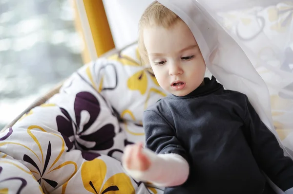 Meisje kijkend naar haar verbonden hand — Stockfoto