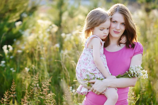 Jonge moeder en een klein meisje in een weide — Stockfoto