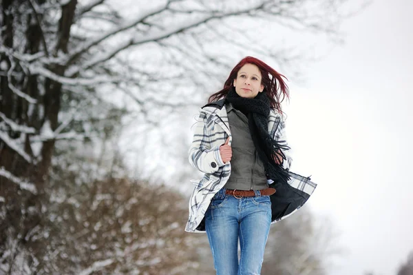 Jonge vrouw in besneeuwde bos — Stockfoto