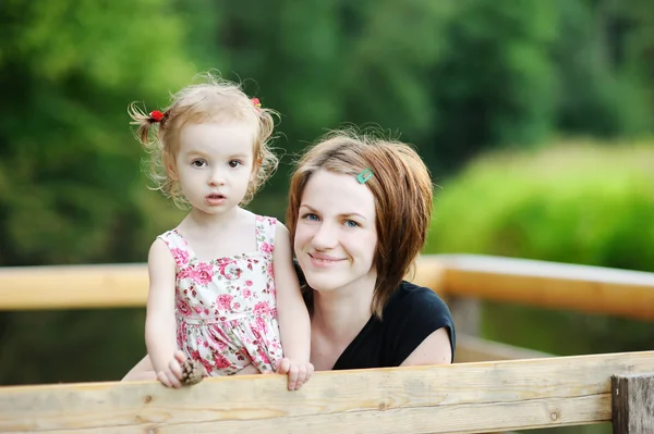 Jonge moeder houden haar schattig meisje — Stockfoto