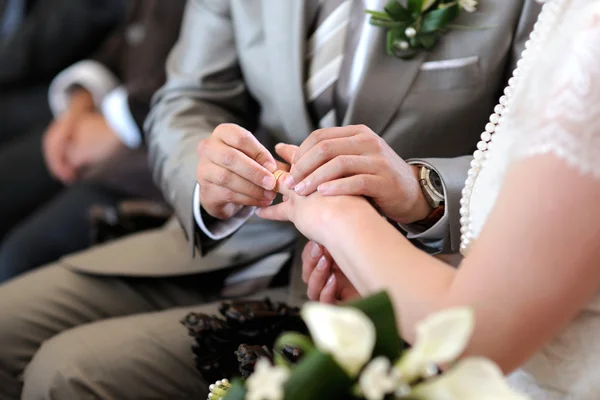 Novio poniendo un anillo en el dedo de la novia — Foto de Stock