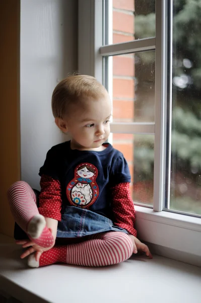 Dwa lata stary maluch dziewczyna przez okno — Zdjęcie stockowe