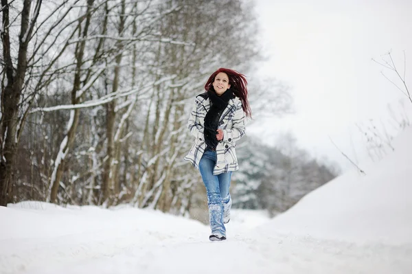 Jonge vrouw in besneeuwde bos — Stockfoto