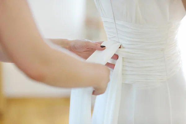 Helping the bride to put a wedding dress on — Stock Photo, Image