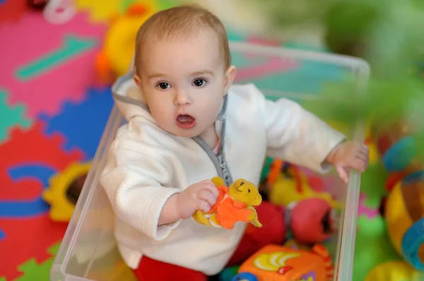 Söt liten tjej i en leksak låda under granen — Stockfoto
