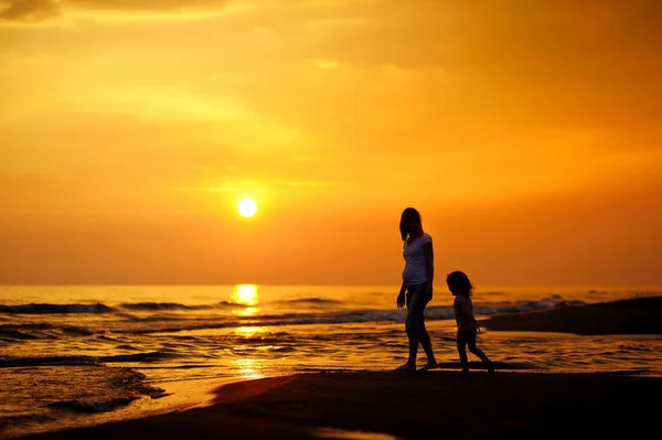 Mère enceinte et son enfant comme silhouettes — Photo