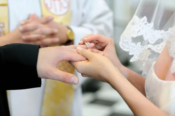 Noiva colocando um anel no dedo do noivo — Fotografia de Stock