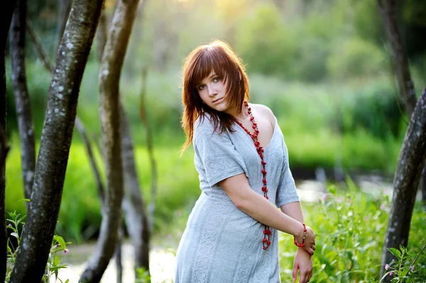 Mulher bonita nova em um por do sol — Fotografia de Stock