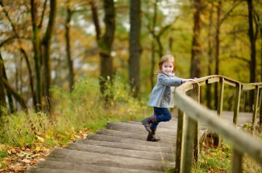 sevimli kız bir sonbahar gününde eğleniyor