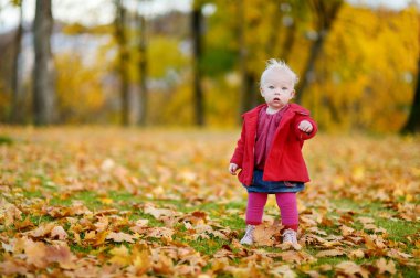 sevimli kız bir sonbahar gününde eğleniyor