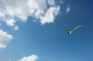 gökyüzündeki bulutlar arasında gökkuşağı uçurtma uçan