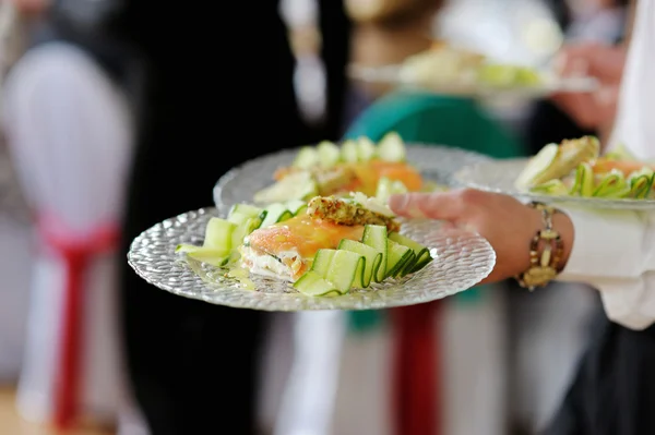 Camarera llevando platos con plato de pescado — Foto de Stock