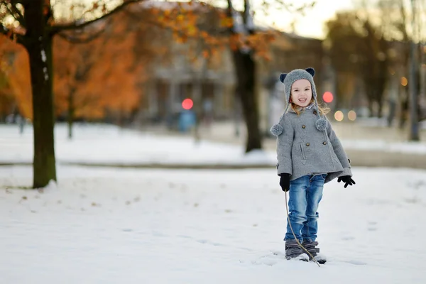 Lilla flickan har kul på vintern city — Stockfoto