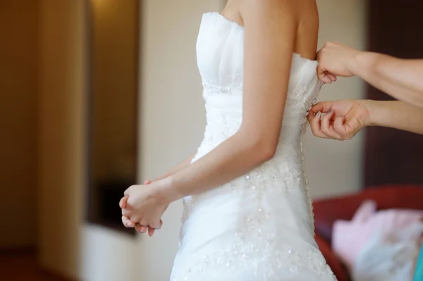 Ajudando a noiva a colocar seu vestido de noiva — Fotografia de Stock