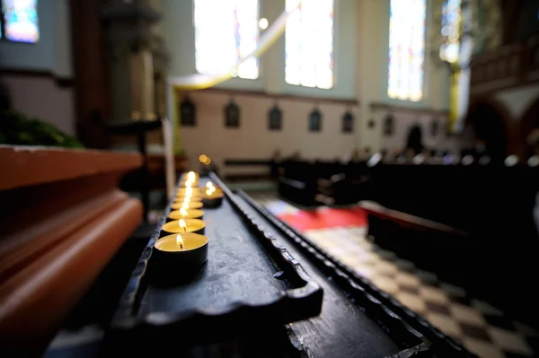 Řádek malých svíček a v kostele — Stock fotografie