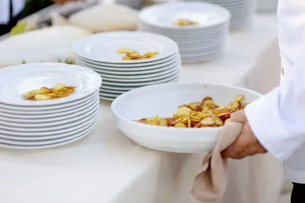 Garçom servindo uma tigela grande de batatas fritas — Fotografia de Stock