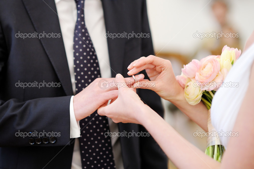 Bride putting the ring on groom's finger