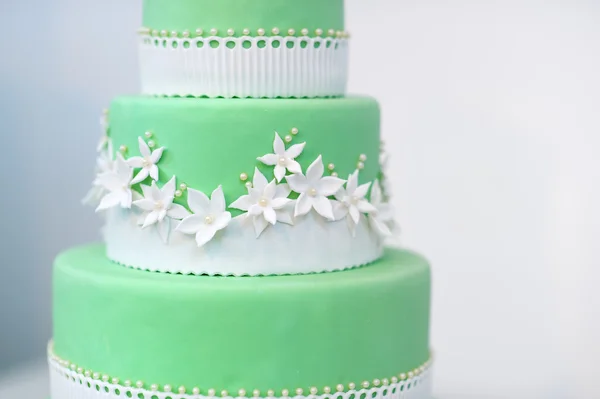 Green wedding cake decorated with white flowers — Stock Photo, Image