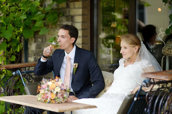 Bruden och brudgummen dricker vin — Stockfoto